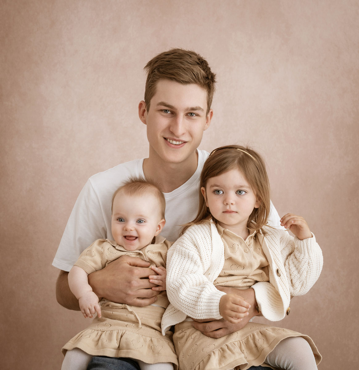 Papa hält seine beiden Töchter auf dem Schoß