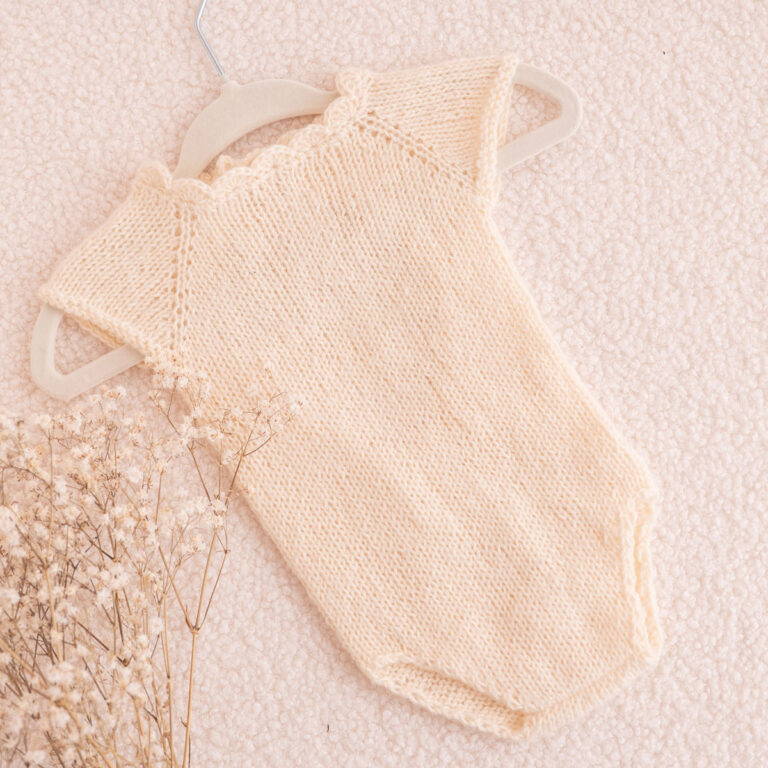 Handgestrickter Baby-Body in Creme mit Muschelkante, ärmellos