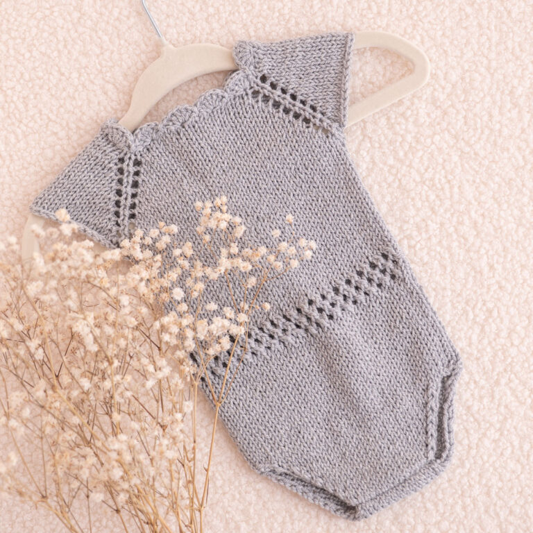 Handgestrickter Baby-Body in Graublau mit Lochmuster und Muschelkante